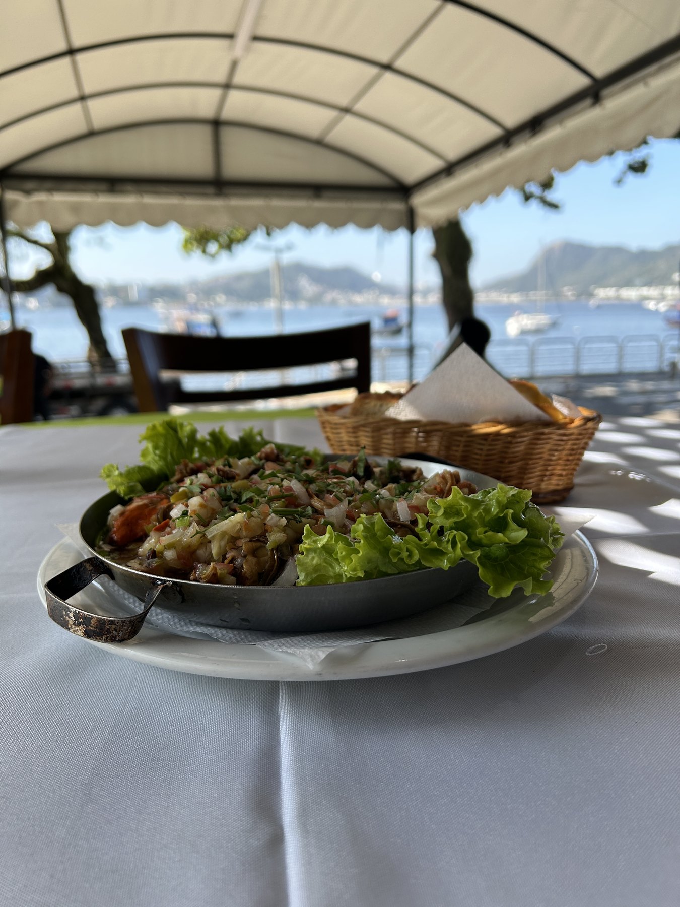 Prato de frutos do mar servido em mesa com vista para a Baía de Guanabara