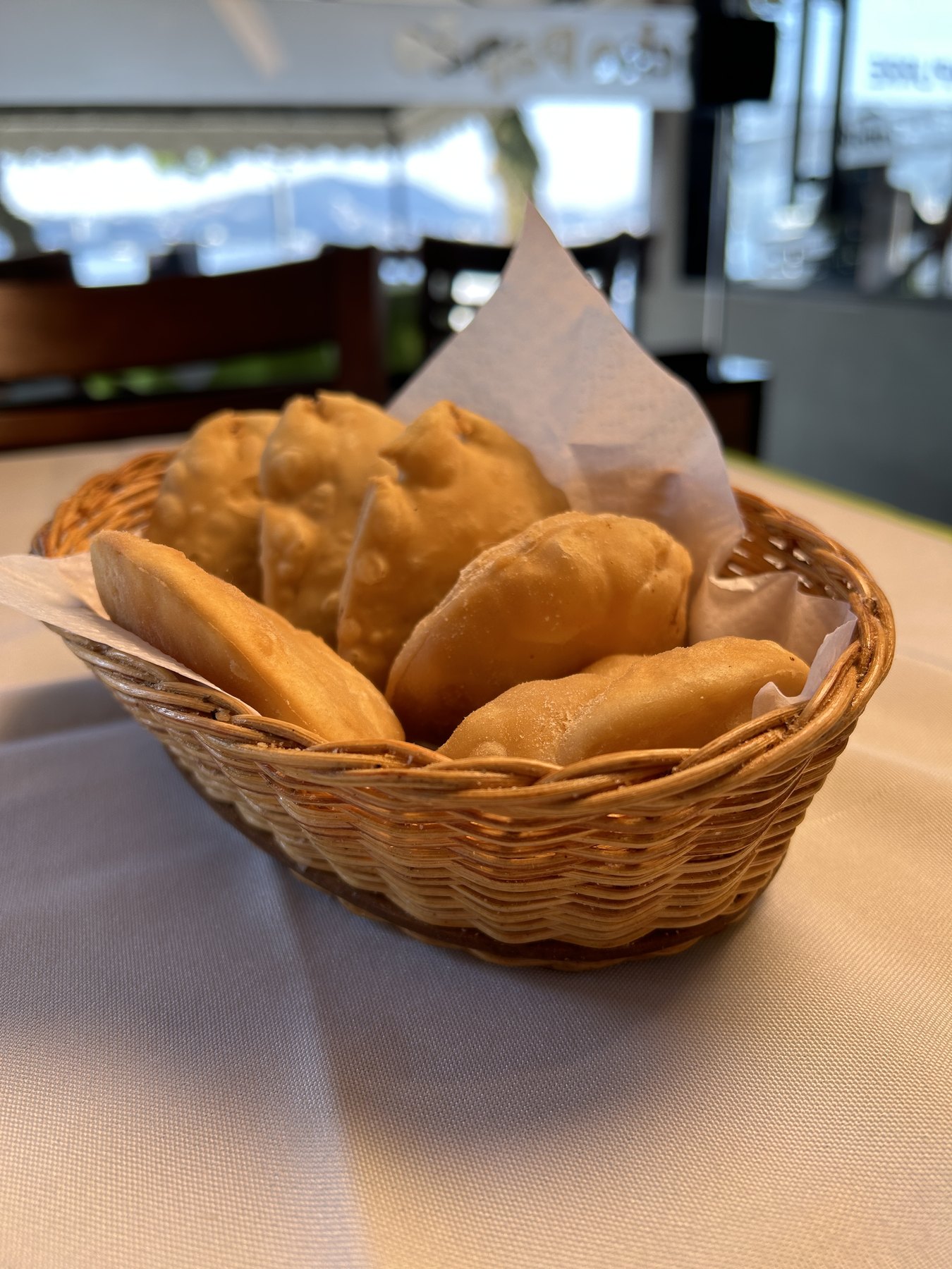 Cesta de pastéis de camarão recém-fritos servida na mesa do rodízio